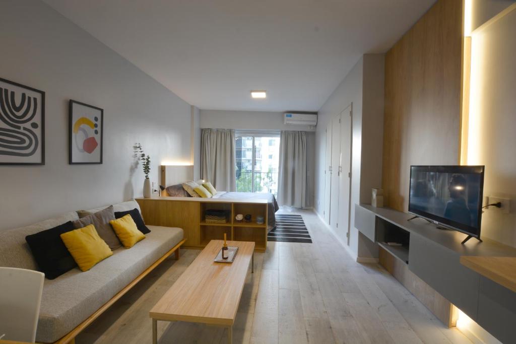ein Wohnzimmer mit einem Sofa und einem TV in der Unterkunft Modern minimal design studio in Recoleta B in Buenos Aires
