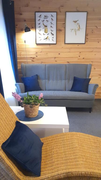 uma sala de estar com um sofá azul e uma mesa em Babie Lato b&b em Uniejow