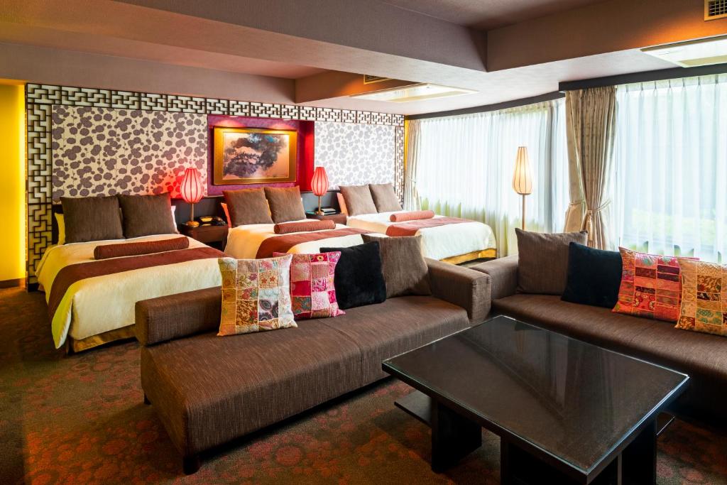 ein Hotelzimmer mit 2 Betten und einem Sofa in der Unterkunft Rose Hotel Yokohama, The Distinctive Collection By WORLDHOTELS in Yokohama