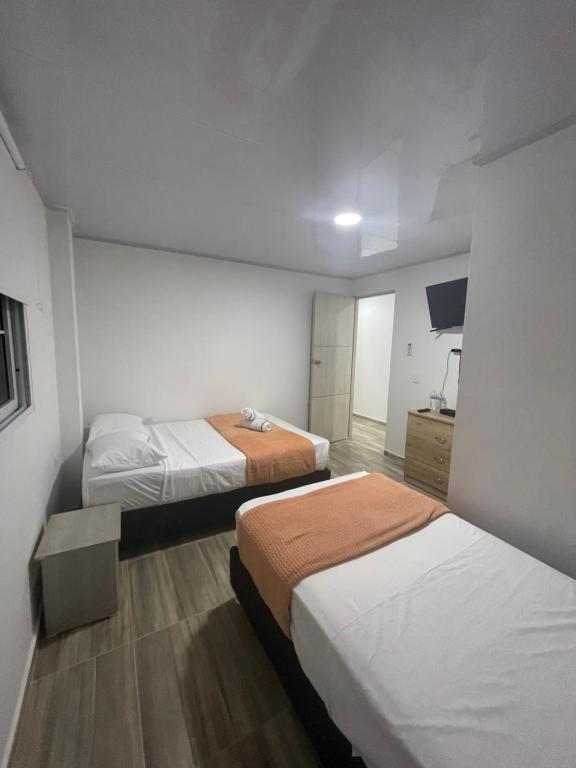 a hotel room with two beds and a television at Providence Paradise Apartamento in Providencia