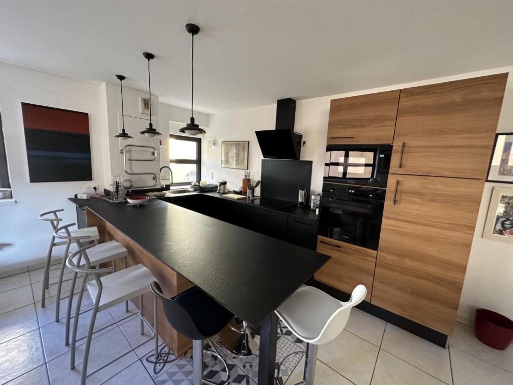 kuchnia z czarnym blatem i białymi krzesłami w obiekcie Appartement T3 avec terrasse, centre Port-Vendres, calme et proche des quais, 6 personnes - FR-1-309-365 w mieście Port-Vendres