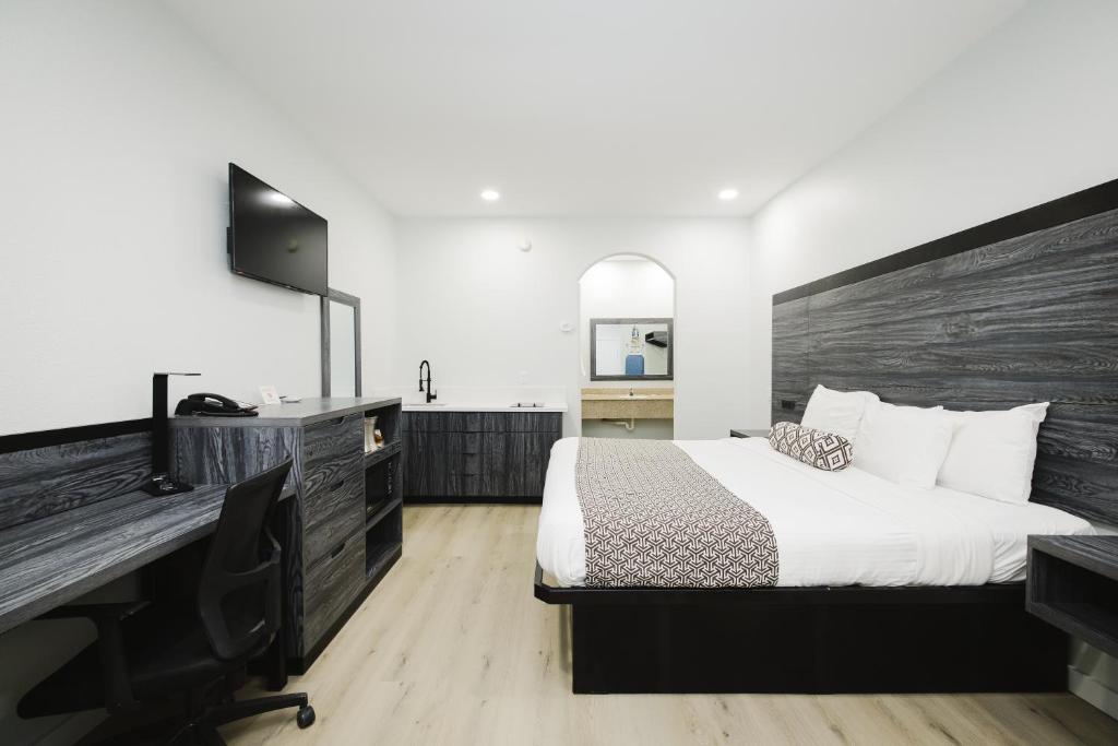 a bedroom with a bed and a desk and a computer at Sapphire Inn & Suites in Deer Park