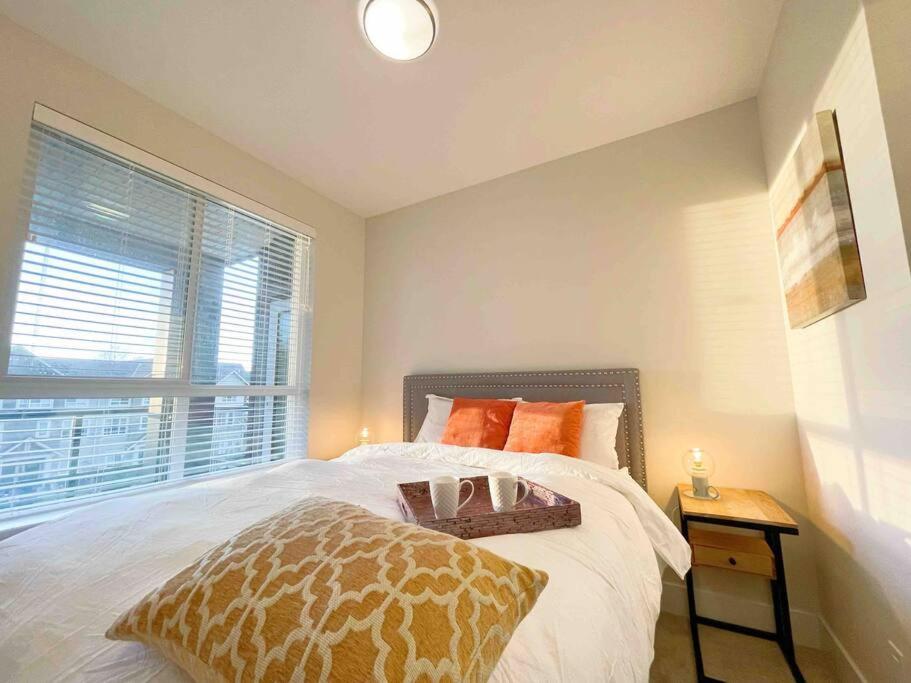 a bedroom with a large bed and a window at Sunny 2 bedrooms+2baths @Tsawwassen condo in Delta