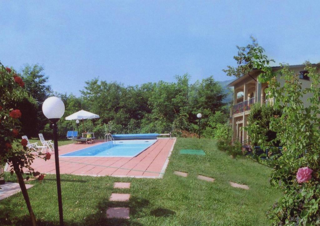 a backyard with a swimming pool and a house at Hotel The Marquee in Castelnuovo di Garfagnana