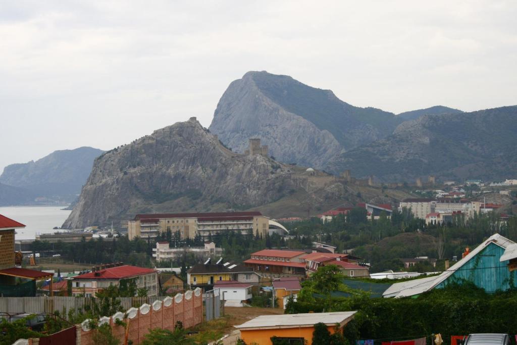 Vistas a una ciudad con montañas en el fondo en Guest House u Timura, en Sudak