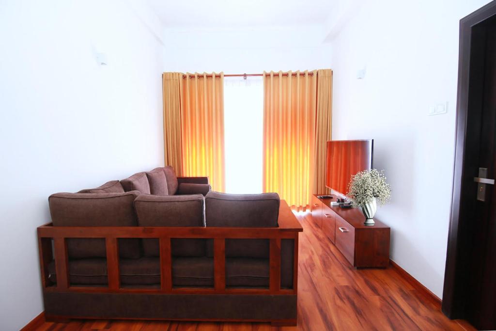 a living room with a couch and a television at Avenue Nuwara Eliya in Nuwara Eliya