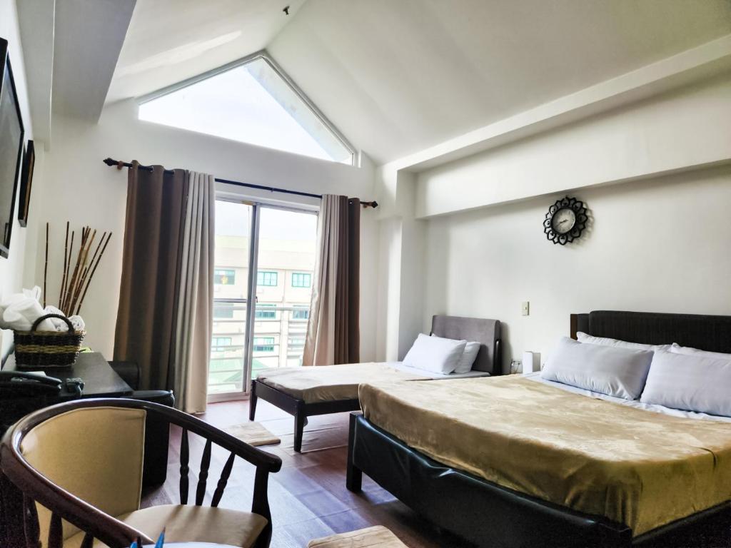 a bedroom with a large bed and a window at The Besh Place - Baguio City in Baguio