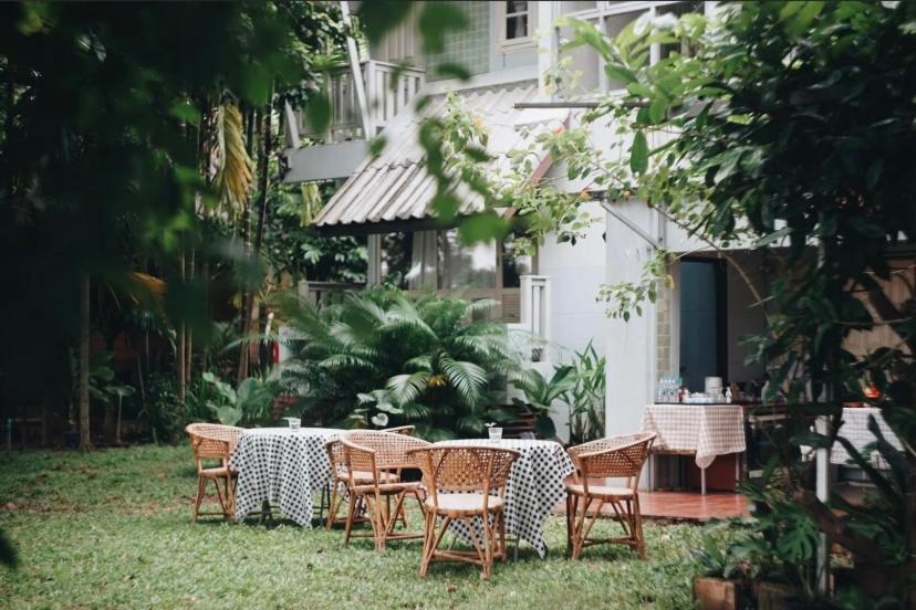 a table and chairs in the yard of a house at เฮือนริมน่าน Huen Rim Nan in Nan