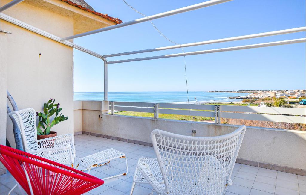 balcone con sedie e vista sull'oceano di Awesome Apartment In Marina Di Ragusa With Kitchenette a Marina di Ragusa