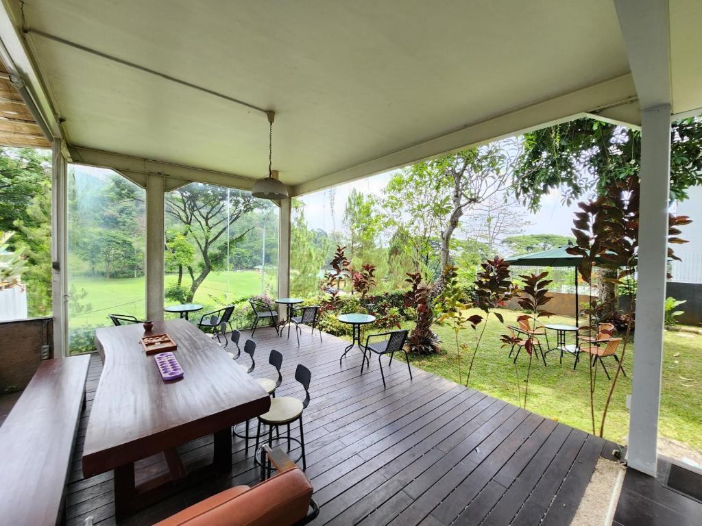 una gran terraza con mesa y sillas. en Jagad House en Pasuruan