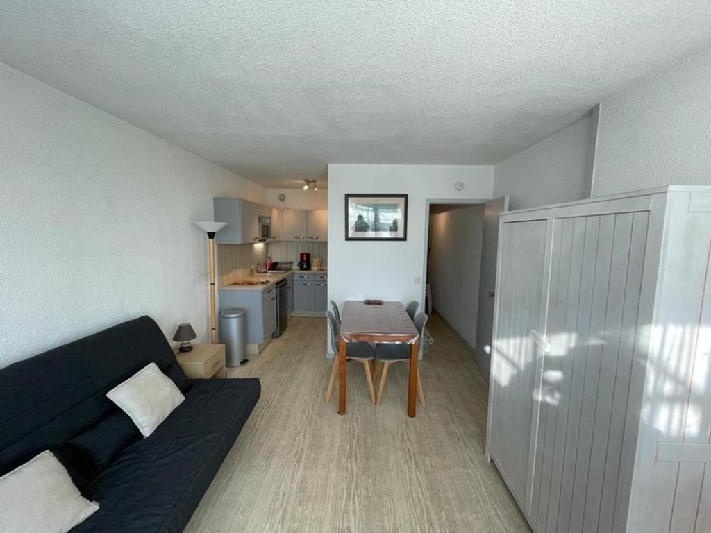 a living room with a black couch and a table at Studio Capbreton, 1 pièce, 4 personnes - FR-1-413-134 in Capbreton