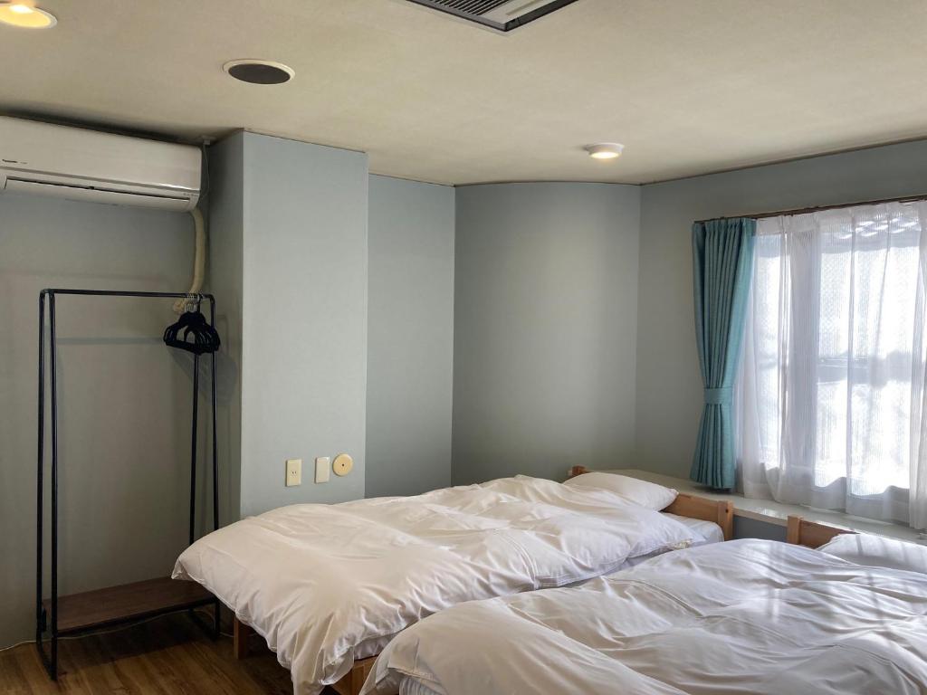 Postel nebo postele na pokoji v ubytování J-Hoppers Beppu Guesthouse ジェイホッパーズ別府ゲストハウス