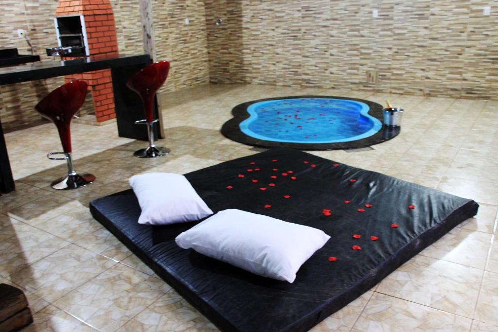 eine Whirlpool-Badewanne mit zwei Kissen in einem Zimmer in der Unterkunft Motel Vitória (Adult only) in Rialma