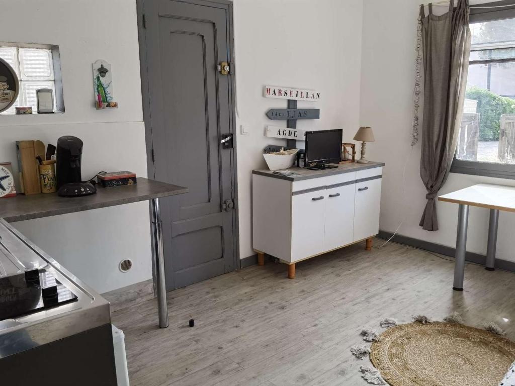 - une cuisine avec un bureau et un ordinateur dans l'établissement Maison en RDC avec Terrasse Sud - 5 Pers., Animaux Admis, Parking - FR-1-326-713, à Marseillan