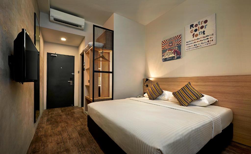 a bedroom with a large white bed and a television at U Hotel Penang in Bayan Lepas