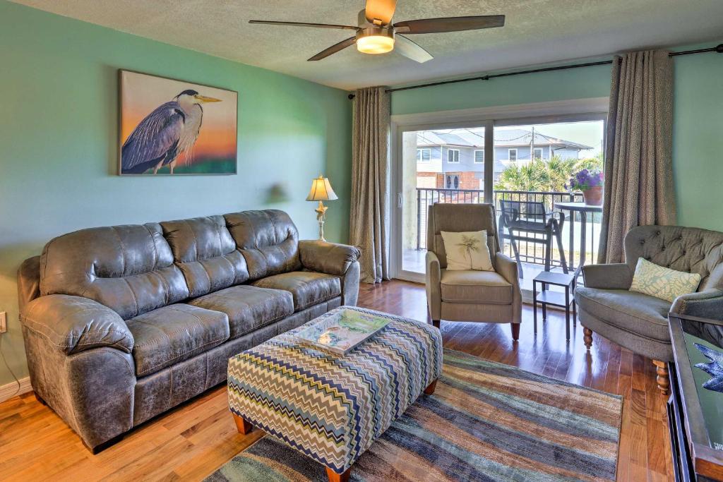 a living room with a leather couch and a tv at Sunny St Augustine Condo with Community Pool! in St. Augustine