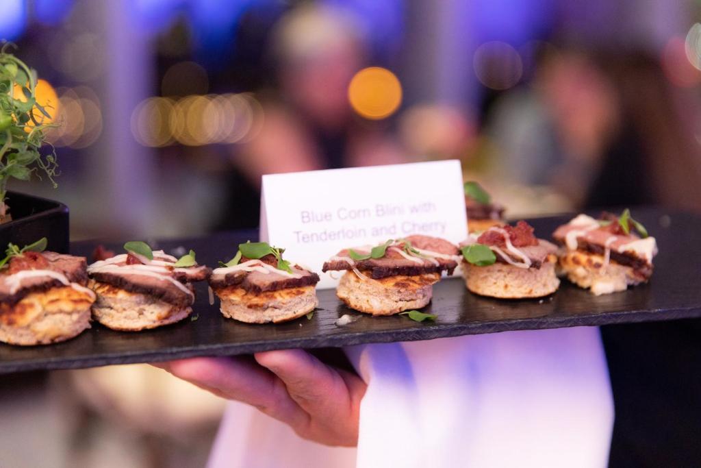 a person holding a tray of food on a table at InterContinental Boston by IHG in Boston