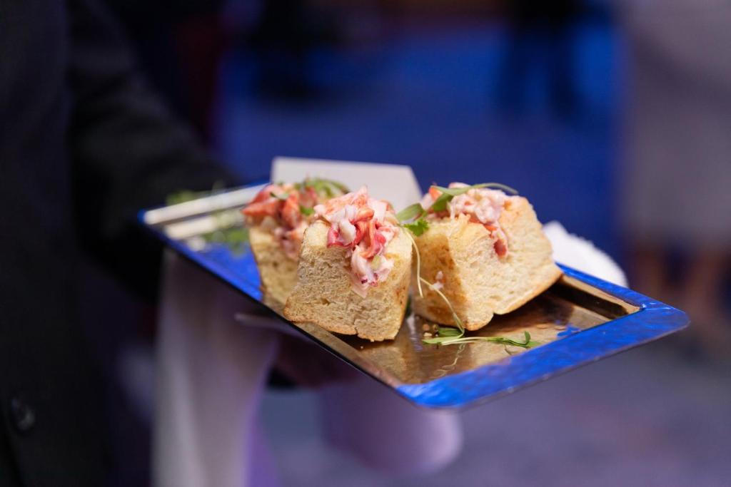 a person holding a plate with a sandwich on it at InterContinental Boston by IHG in Boston