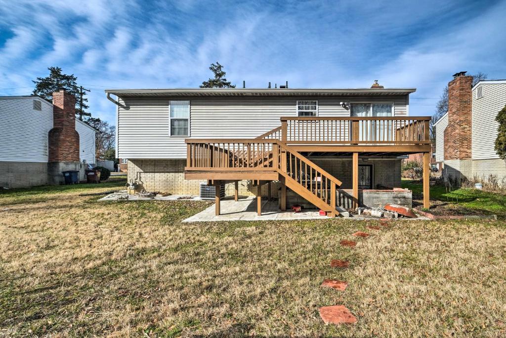 a house with a wooden deck in the yard at Maryland Vacation Home Near US Capital! in Riverdale Park