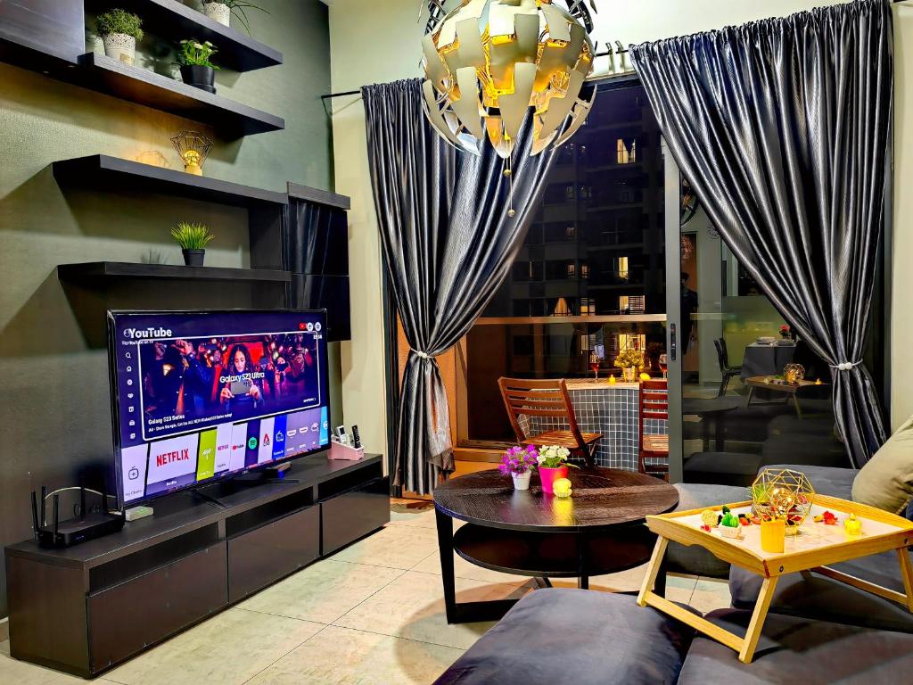 uma sala de estar com uma televisão, um sofá e uma mesa em Petalz Luxury Suite 10Pax MID VALLEY OLD KLANG ROAD OUG KLANG LAMA KL em Kuala Lumpur