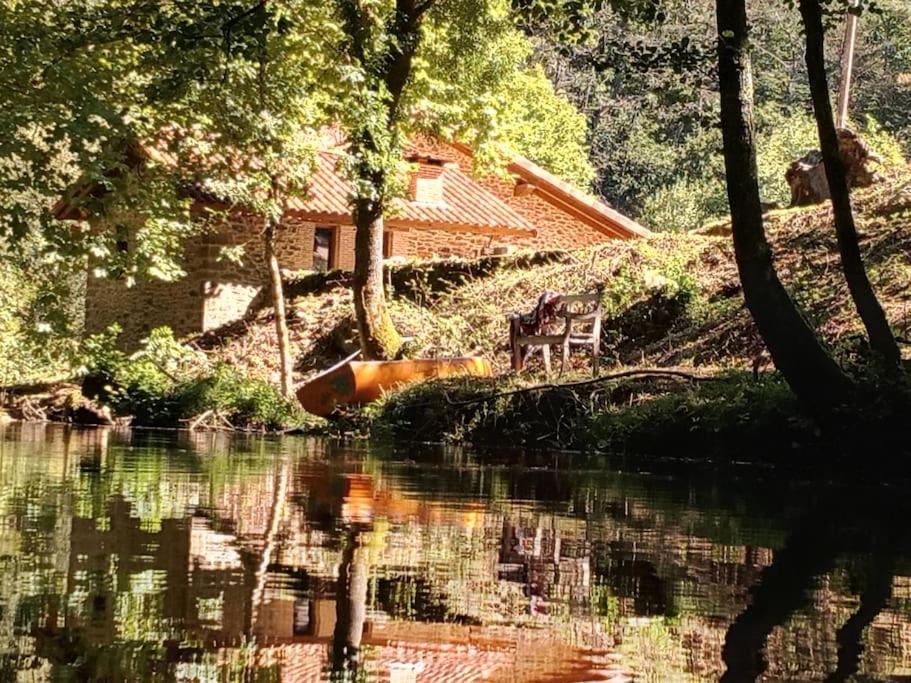 a house on a hill next to a river with trees at Haraneko Errota Burdindegi in El Cerco