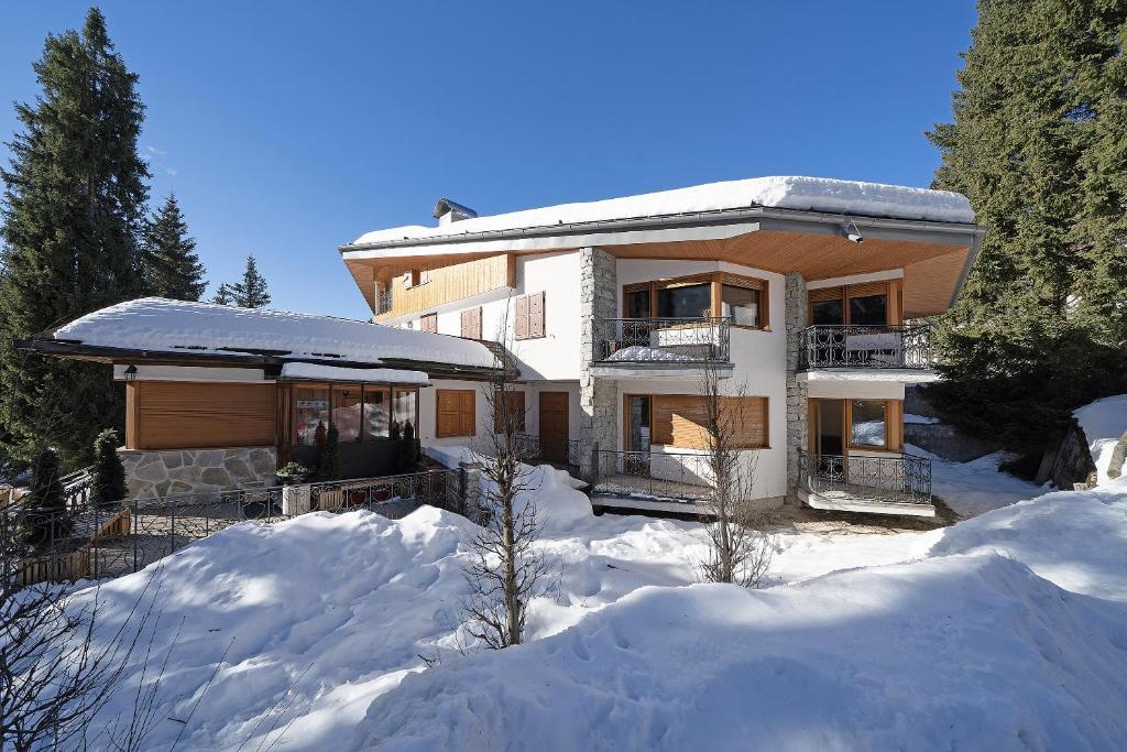 una casa con la neve davanti di Nuovo Appartamento Super Vista a Campiglio Parking Privato a Madonna di Campiglio