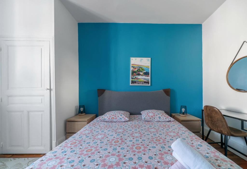 1 dormitorio con 1 cama con pared azul en Le 482 - Grand Appartement design & Confort - 4 chambres, en Vichy