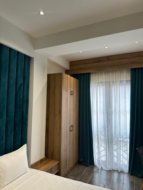 1 dormitorio con cortinas verdes, 1 cama y ventana en Отель AuRoom Ванадзор, en Vanadzor