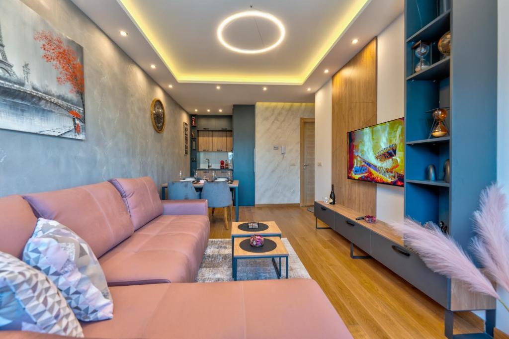 uma sala de estar com um sofá e uma televisão em Mount Inn La Boheme em Zlatibor
