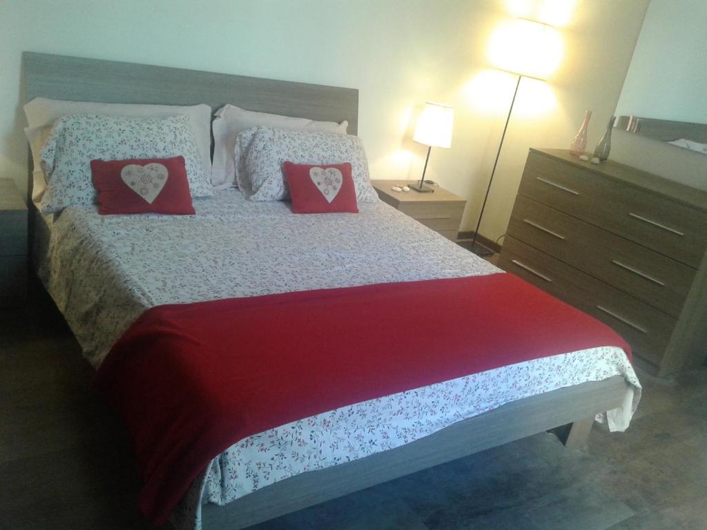 1 dormitorio con 1 cama con 2 almohadas rojas en Testaccio Roma Style Apartment, en Roma