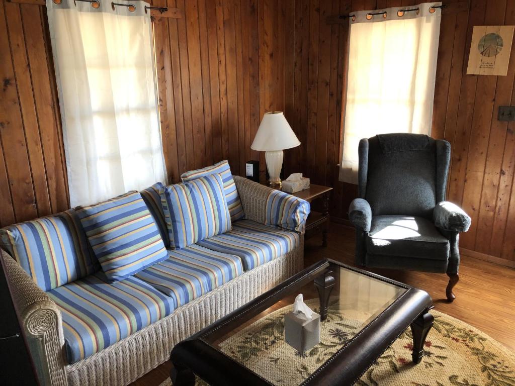 a living room with a couch and a chair at BlackBeard's Retreat - Historic and Pet Friendly cottage in Kitty Hawk