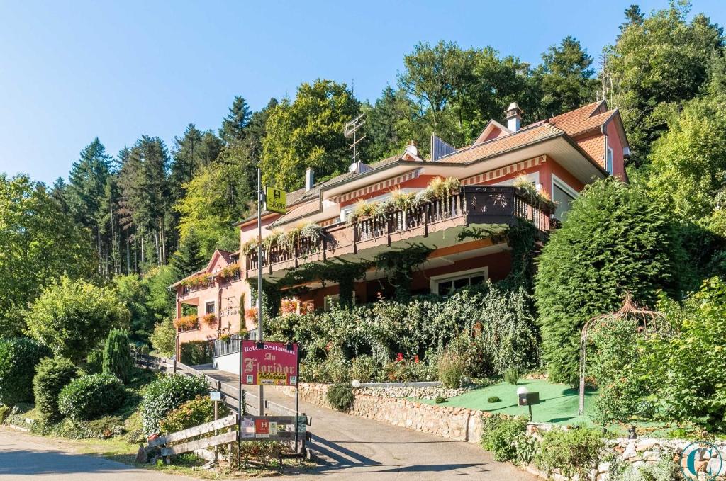 une grande maison sur le côté d'une colline avec des arbres dans l'établissement Hotel Restaurant au Floridor, à Thann