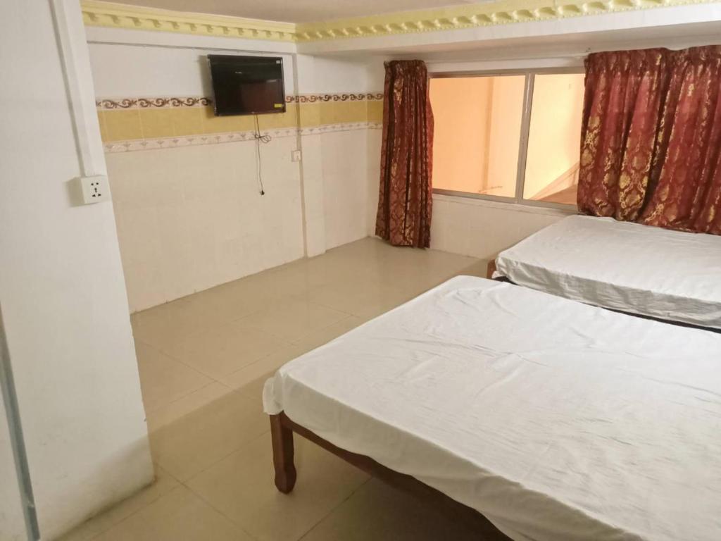 a hotel room with two beds and a television at Good Luck Hostel in Phnom Penh
