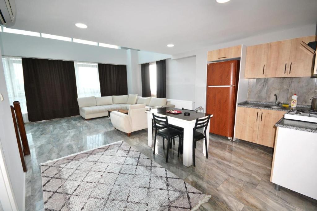 a kitchen and a living room with a table and chairs at Garden Park in Esenyurt