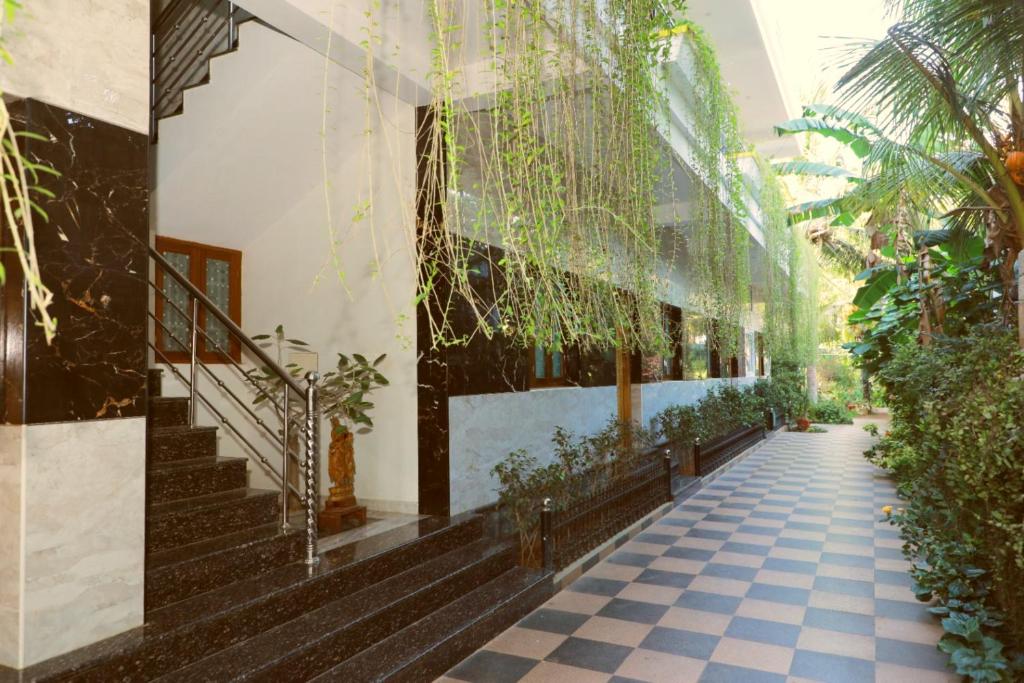 a hallway of a building with plants and stairs at Farmdean Resort in Kanyakumari