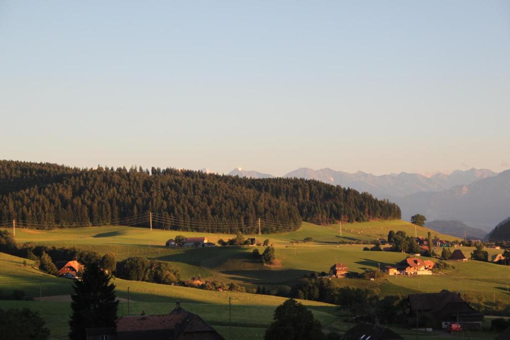 a green hillside with houses and trees and mountains at Like on cloud nine - Apartment in Emmental 