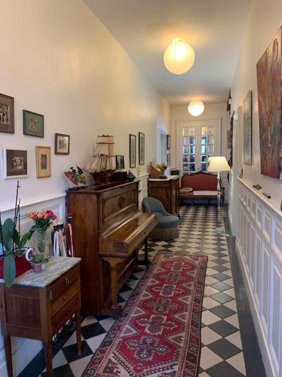 a hallway with a piano and a living room at Le Moulin du Carla in Lavaur