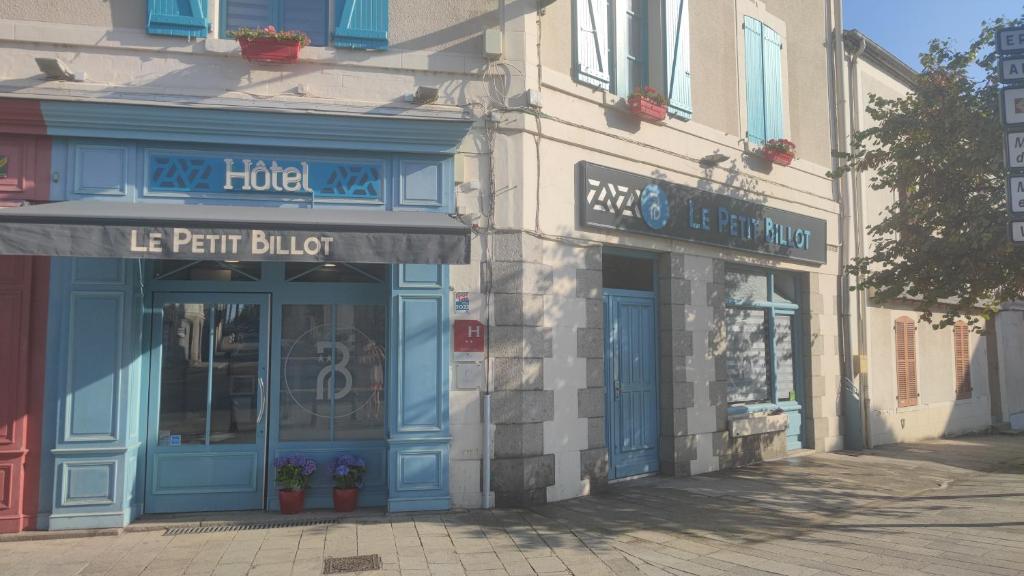 a building with blue doors and windows on a street at Hotel Le Petit Billot in Vitré