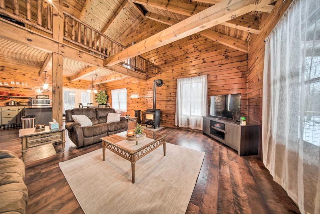 a living room with a couch and a tv and a table at Cabin in Lake Chautauqua on 36 Acres with Hot Tub! in Ashville