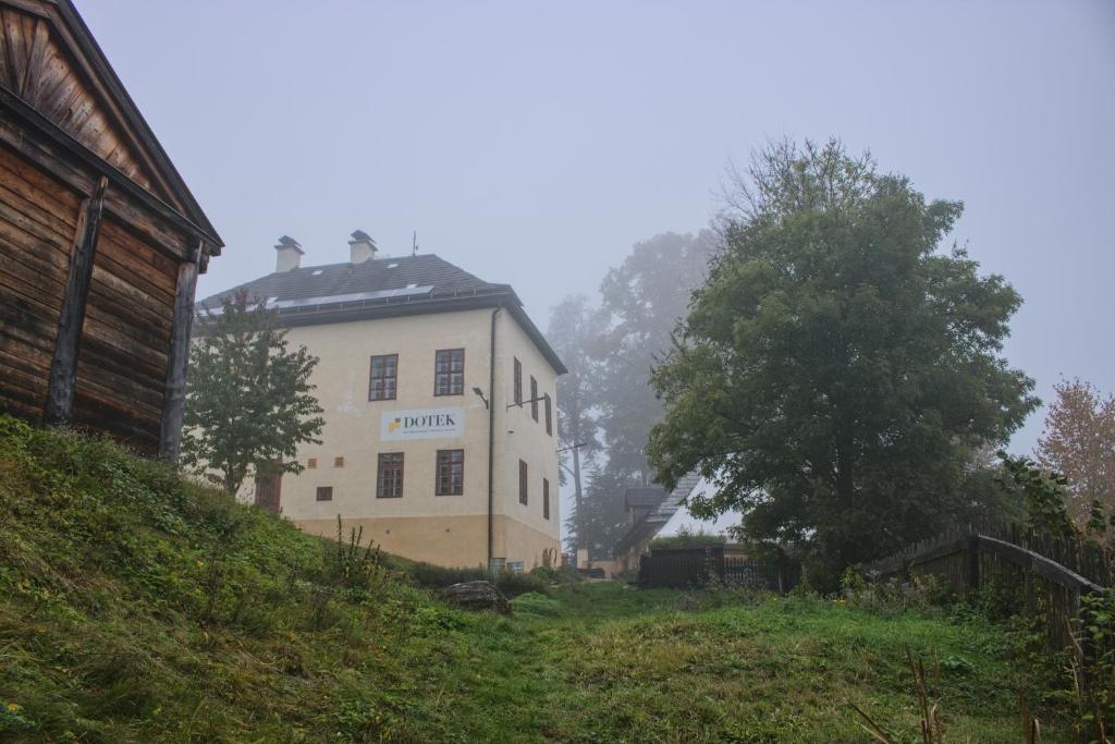 a white building on a hill in the fog at Ekocentrum DOTEK in Horn&iacute; Mar&scaron;ov