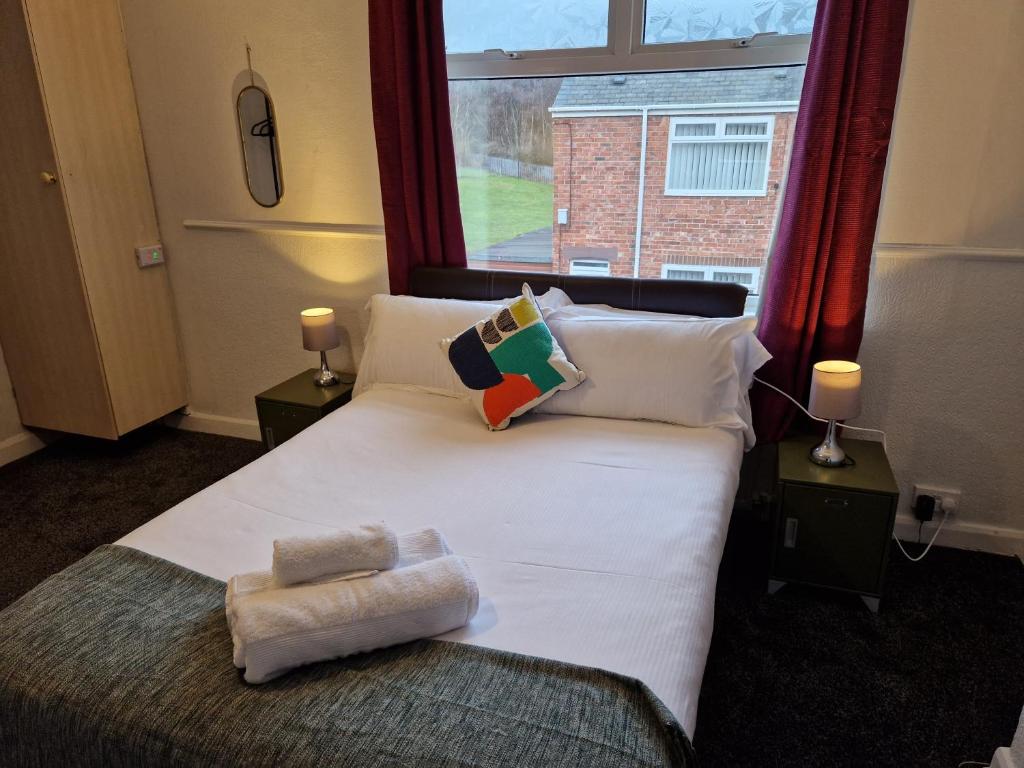 a bedroom with a large white bed with a window at Grange Villa Amethyst 3 Bed House near Chester le Street, sleeps 6 Guests in Chester-le-Street
