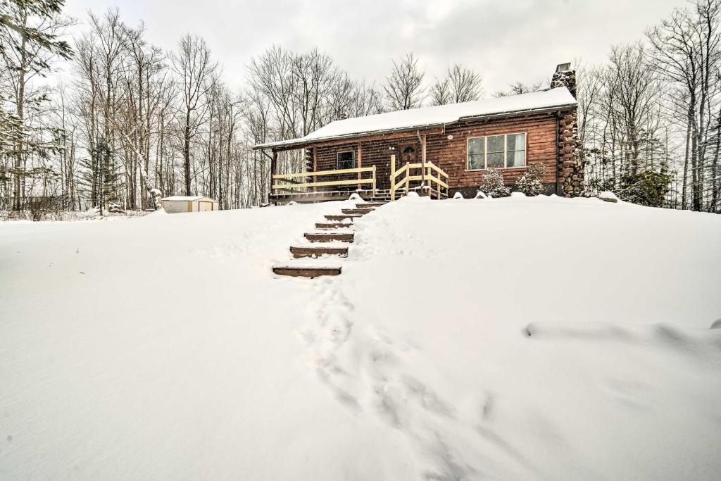 una cabaña de madera en la nieve en frente en Cambridge Springs Cabin Near French Creek!, en Cambridge Springs
