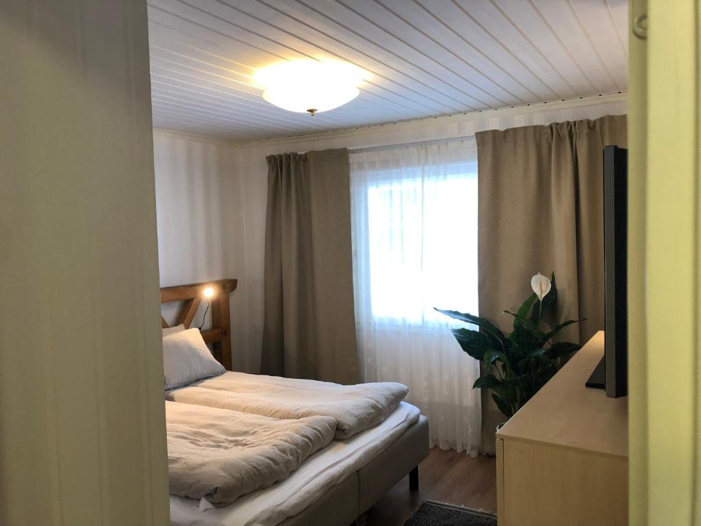 a small bedroom with a bed and a window at Kiviharjun B&B in Kotka