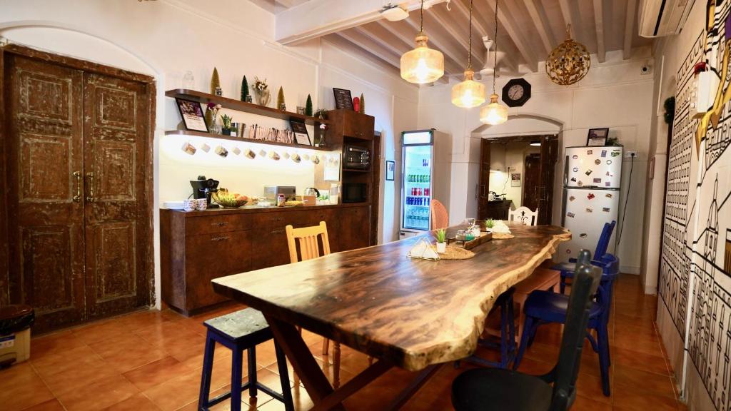 uma cozinha com uma grande mesa de madeira e cadeiras em GoSolo Stays em Mumbai