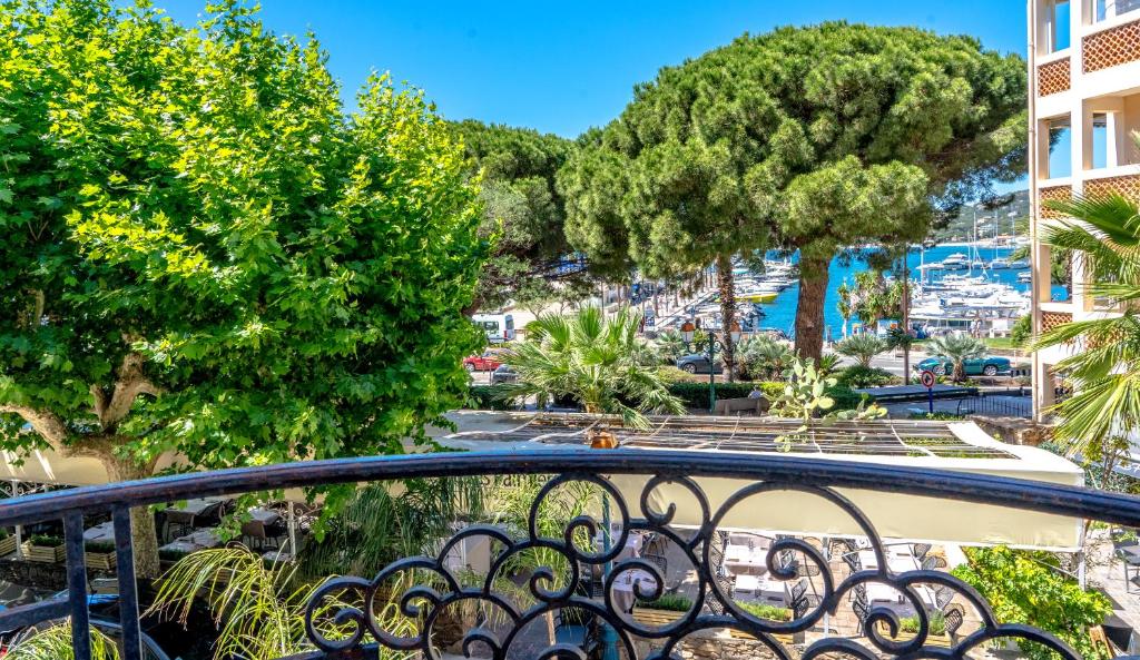 a balcony with trees and a view of a city at Hotel Les Palmiers in Sainte-Maxime