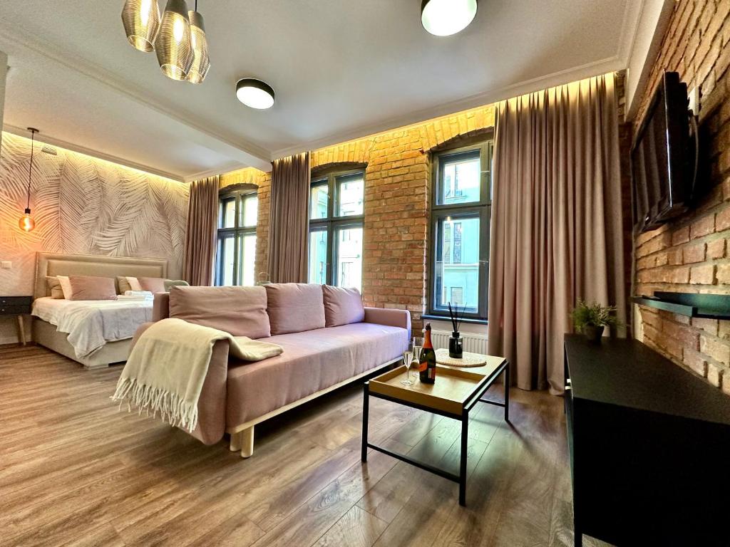 a living room with a couch and a bed at PasteLove Okna in Toruń