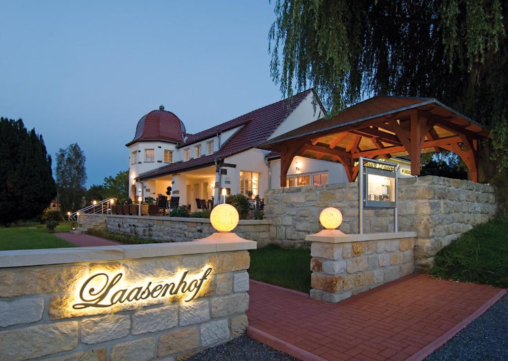 a home with a stone wall and a wooden gazebo at Laasenhof Resort in Struppen