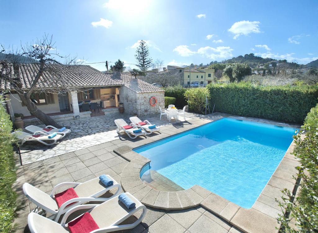 una piscina con sillas y una casa en Owl Booking Villa Can Gorreta - 5 Min Walk To The Old Town en Pollença