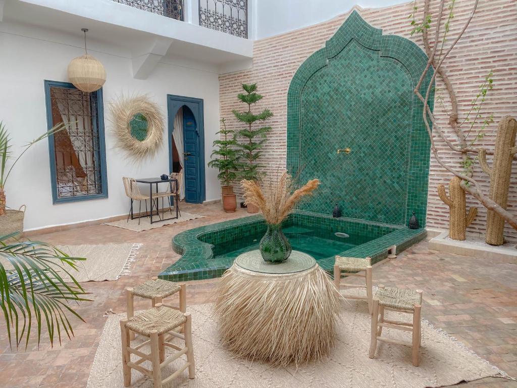 a patio with a tub with a table and chairs at Riad Dar Marrakcha in Marrakech