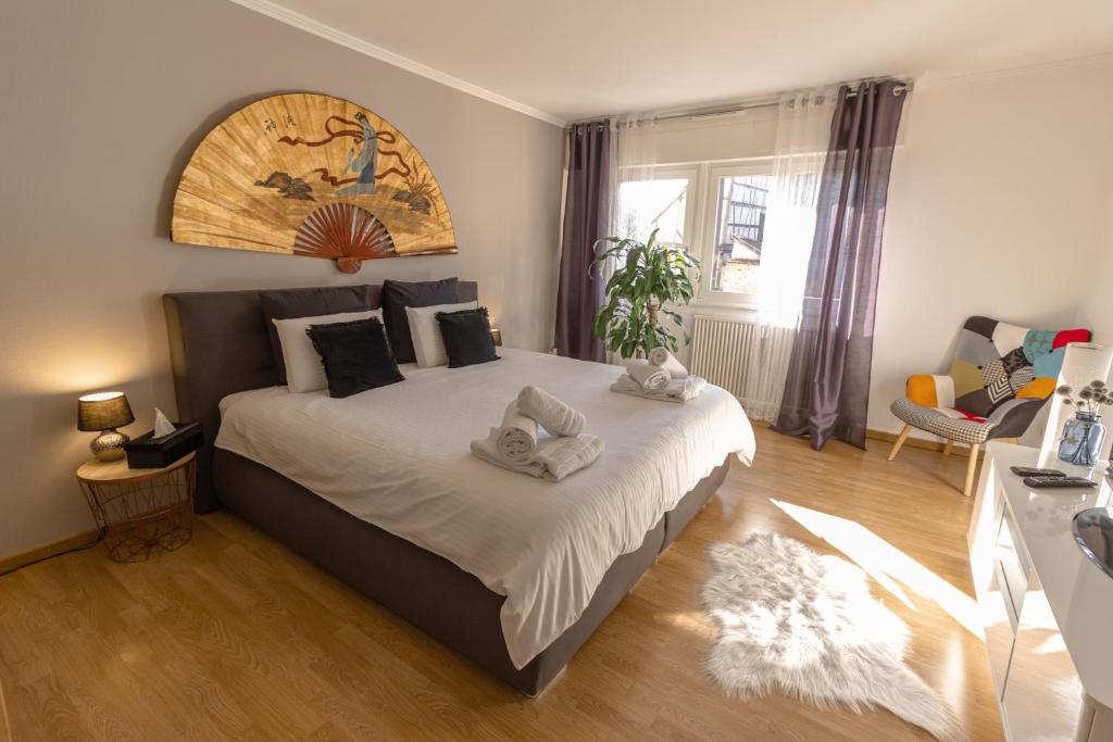 Un dormitorio con una cama grande con almohadas. en Le gîte de Sabina - Colmar, en Colmar